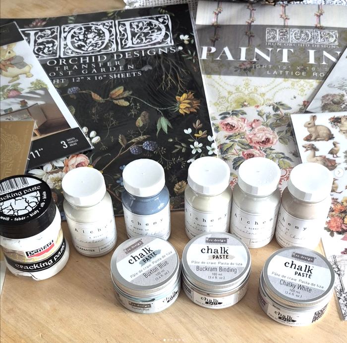 Chalk paints, transfers and craft materials on the workbench
